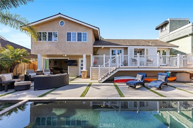 rear view of house featuring an outdoor hangout area, a wooden deck, a patio, and fence