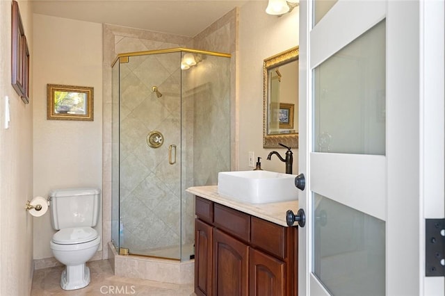 bathroom featuring vanity, toilet, a stall shower, and tile patterned flooring