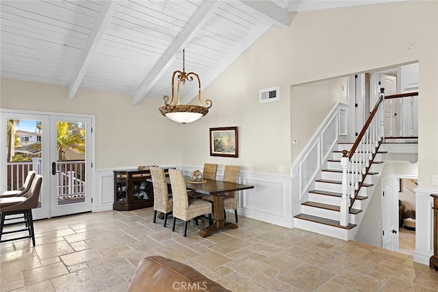 dining space with visible vents, beam ceiling, stone tile flooring, french doors, and stairs