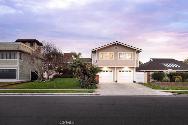 view of front of home featuring driveway, a front yard, and a garage