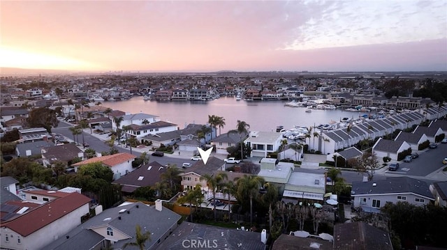 aerial view at dusk featuring a water view