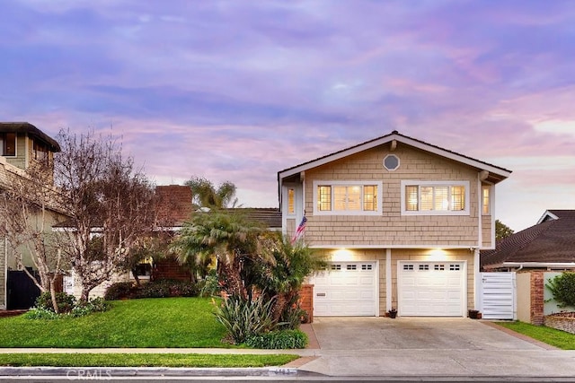 view of front of property with a lawn, driveway, and an attached garage