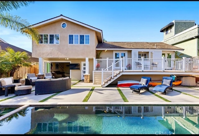 rear view of house with a wooden deck, a patio, outdoor lounge area, and fence