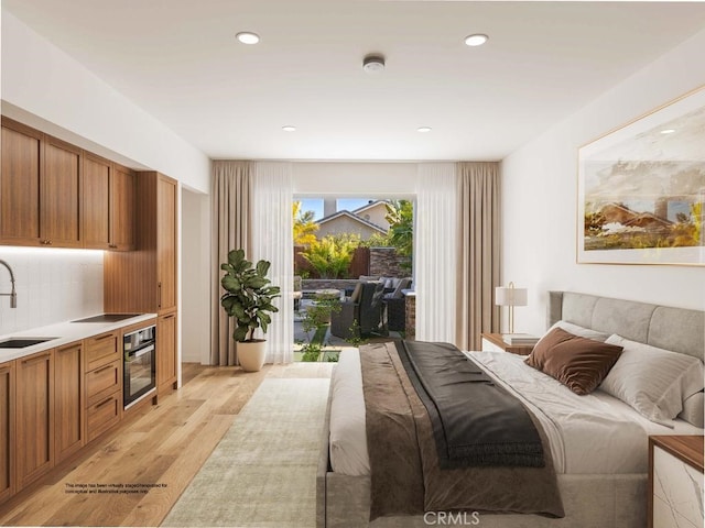 bedroom with access to exterior, recessed lighting, light wood finished floors, and a sink