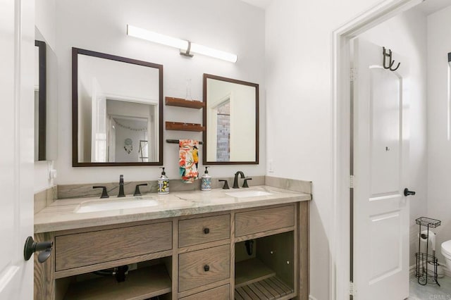 full bathroom featuring a sink, toilet, and double vanity