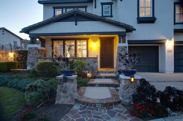 view of front of home featuring stucco siding, stone siding, driveway, and an attached garage