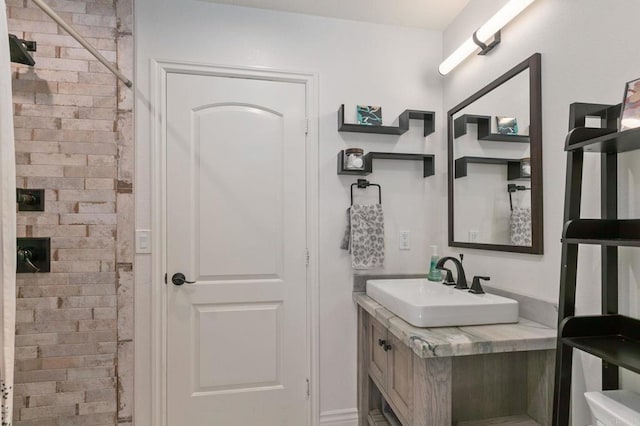 full bath with a tile shower and vanity