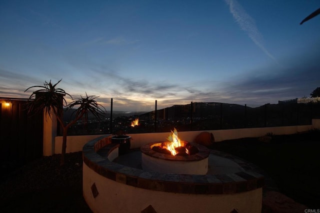 patio terrace at dusk with fence and an outdoor fire pit