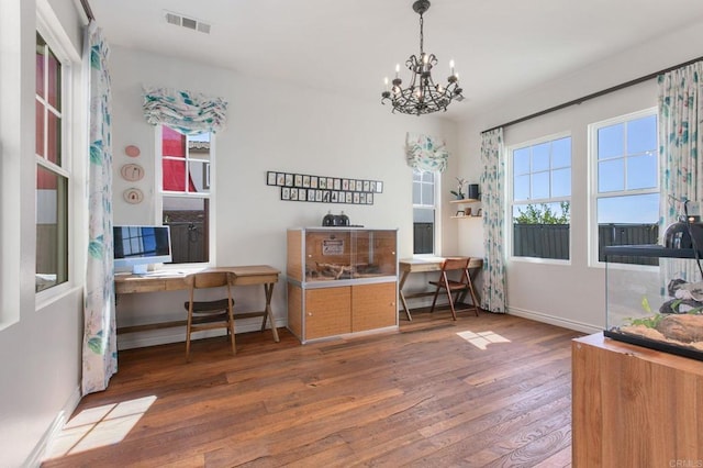 home office featuring visible vents, baseboards, hardwood / wood-style floors, and a chandelier