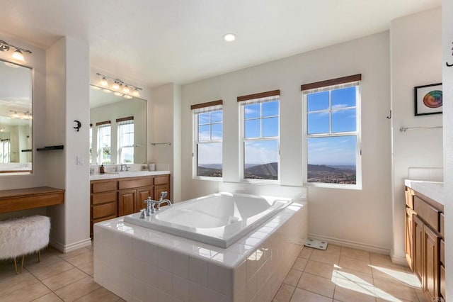 full bath with a bath, vanity, and tile patterned flooring