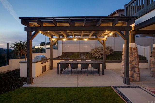 view of patio featuring a grill, exterior kitchen, a pergola, and fence