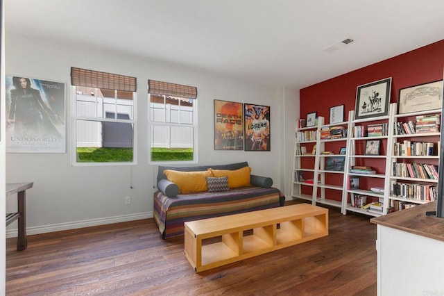 living area featuring visible vents, baseboards, and wood finished floors