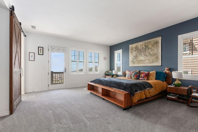 carpeted bedroom with a barn door, access to exterior, visible vents, and baseboards