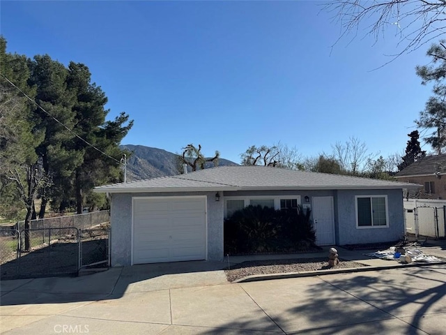 ranch-style house featuring concrete driveway, stucco siding, fence, a gate, and a garage