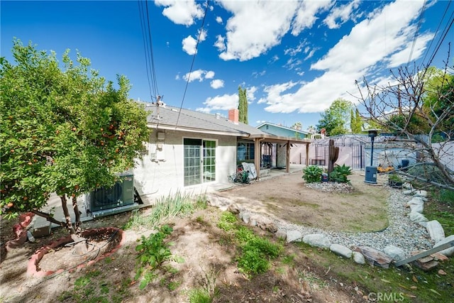 back of house featuring a patio, stucco siding, and central air condition unit