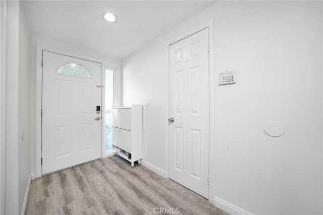 foyer with light wood-type flooring and baseboards