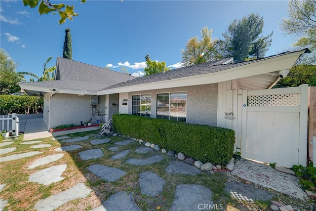 ranch-style home featuring fence and stucco siding