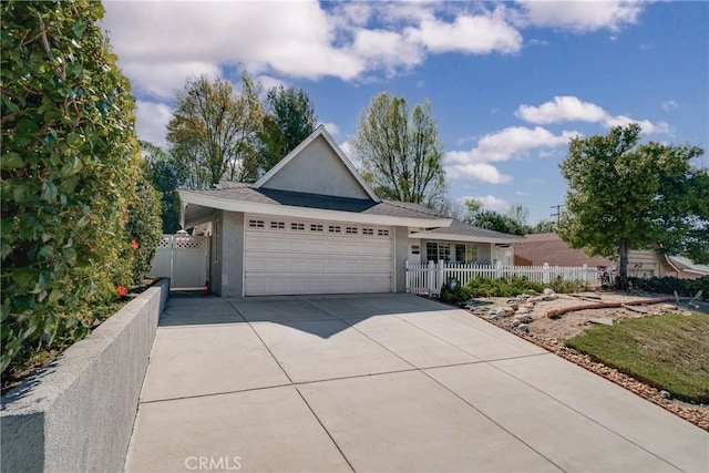 single story home featuring an attached garage, driveway, fence, and stucco siding