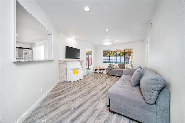 living room with baseboards, wood finished floors, and recessed lighting