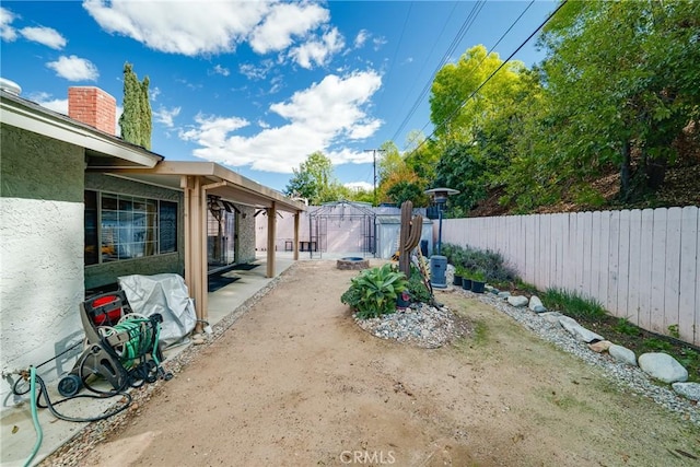 view of yard with a fenced backyard, an outdoor structure, and a patio