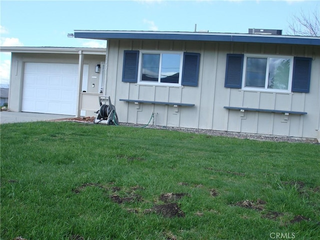 ranch-style home featuring board and batten siding, a front yard, and an attached garage