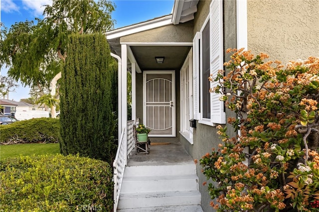 entrance to property featuring stucco siding