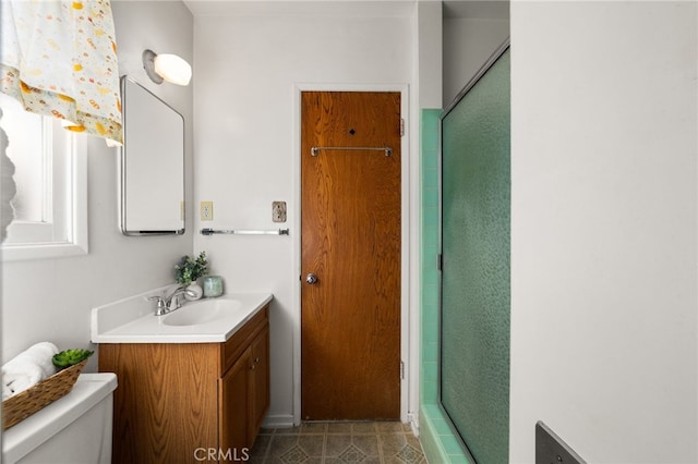 bathroom with tile patterned flooring, a shower stall, toilet, and vanity