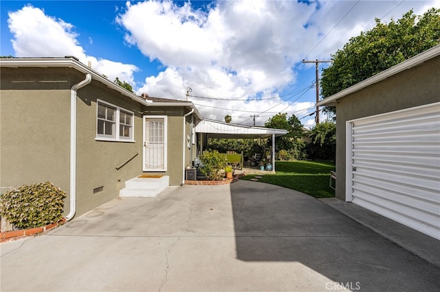 exterior space featuring crawl space, a patio, a lawn, and stucco siding