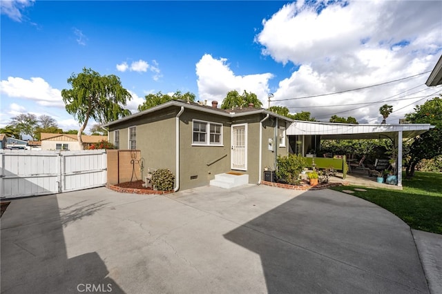 back of property featuring a patio area, a gate, and stucco siding