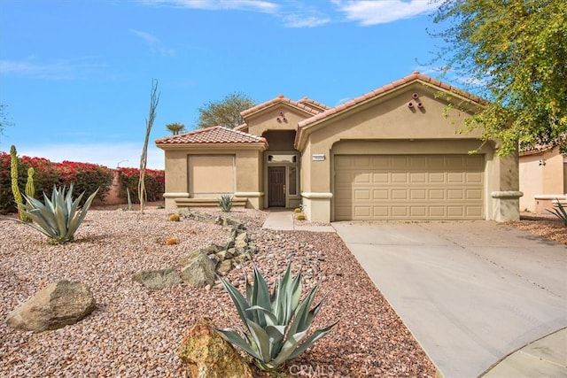 mediterranean / spanish-style home featuring concrete driveway, a tile roof, an attached garage, and stucco siding