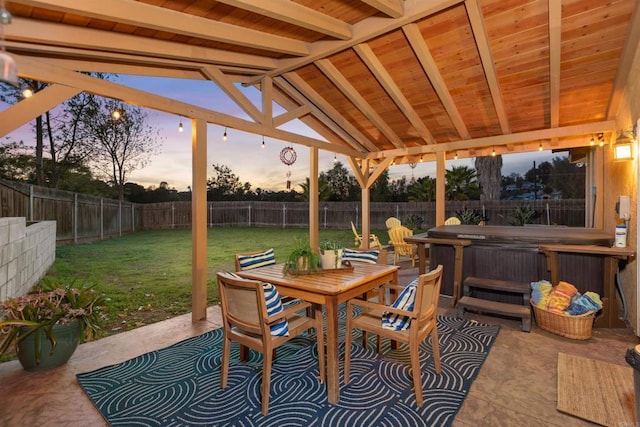 view of patio with outdoor dining area, a fenced backyard, and a hot tub