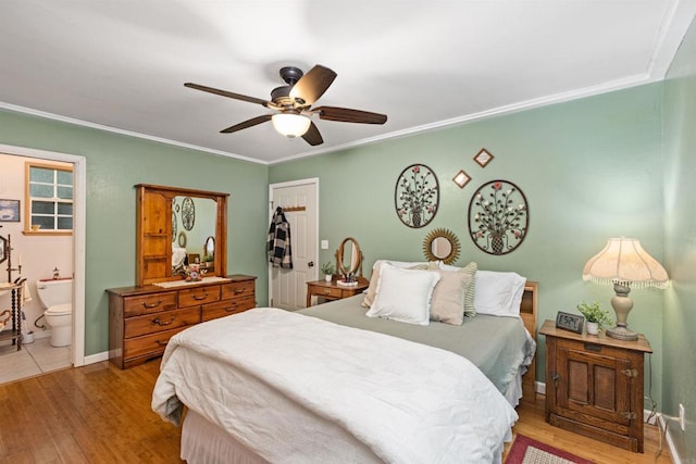 bedroom with ensuite bath, baseboards, light wood finished floors, and ornamental molding