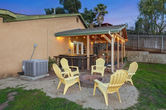 view of patio / terrace featuring central air condition unit, fence, and a fire pit