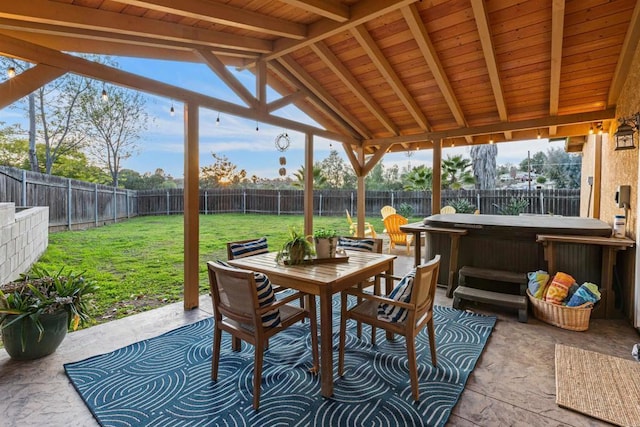 view of patio / terrace with outdoor dining area, a fenced backyard, and a hot tub