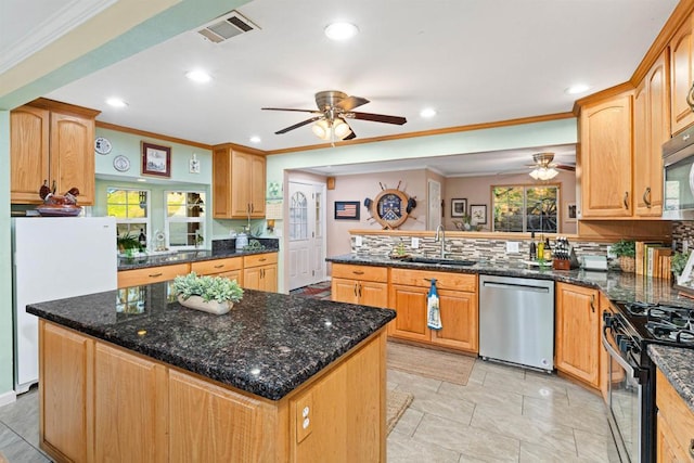 kitchen featuring visible vents, a peninsula, a sink, decorative backsplash, and appliances with stainless steel finishes