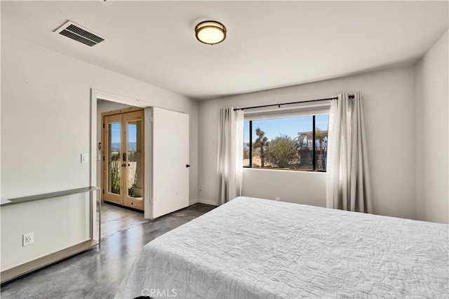 bedroom with finished concrete flooring, access to exterior, visible vents, and french doors