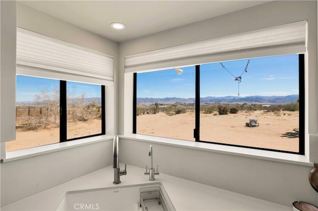 bathroom featuring a healthy amount of sunlight, a mountain view, and a sink