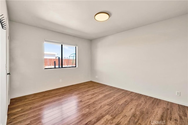 unfurnished room with wood finished floors and baseboards