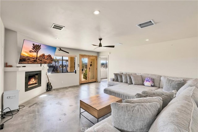 living room featuring recessed lighting, concrete floors, visible vents, and a glass covered fireplace