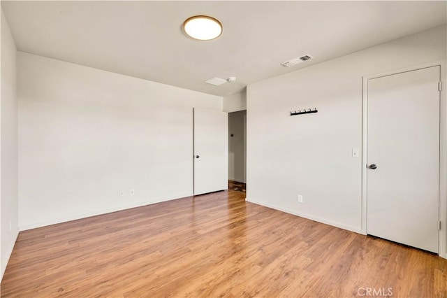 unfurnished room featuring light wood-style floors, baseboards, and visible vents