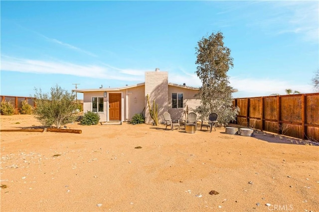 rear view of property with fence and stucco siding