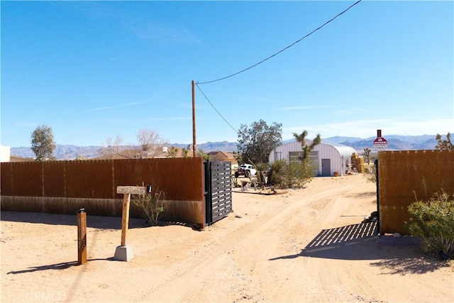 view of street featuring driveway, a gate, and a mountain view