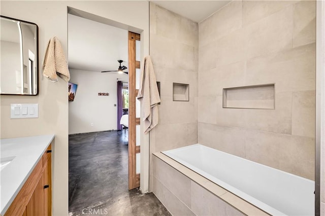 ensuite bathroom featuring ceiling fan, concrete floors, connected bathroom, and vanity