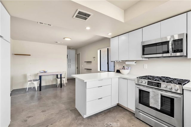 kitchen featuring stainless steel appliances, white cabinets, visible vents, and a peninsula