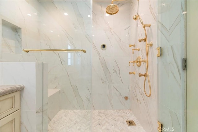 full bath with a marble finish shower and vanity