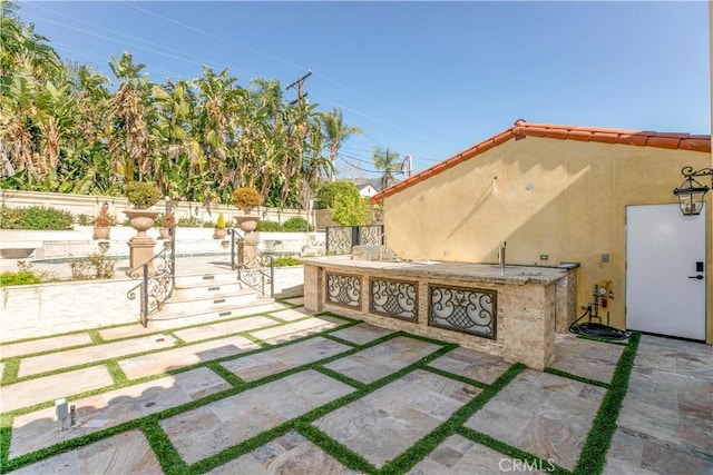 view of patio with an outdoor kitchen and fence