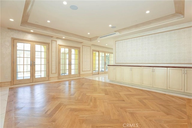 empty room with recessed lighting, french doors, a tray ceiling, and wallpapered walls