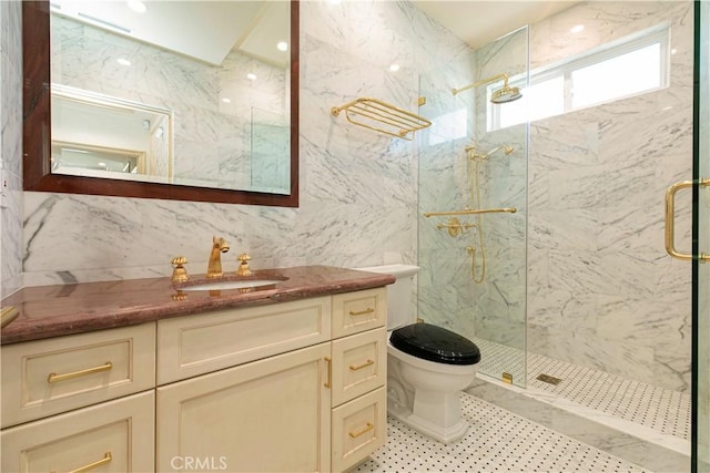 bathroom featuring toilet, vanity, a marble finish shower, and tile walls