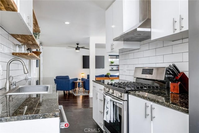 kitchen featuring a sink, wall chimney exhaust hood, white cabinets, and stainless steel range with gas stovetop