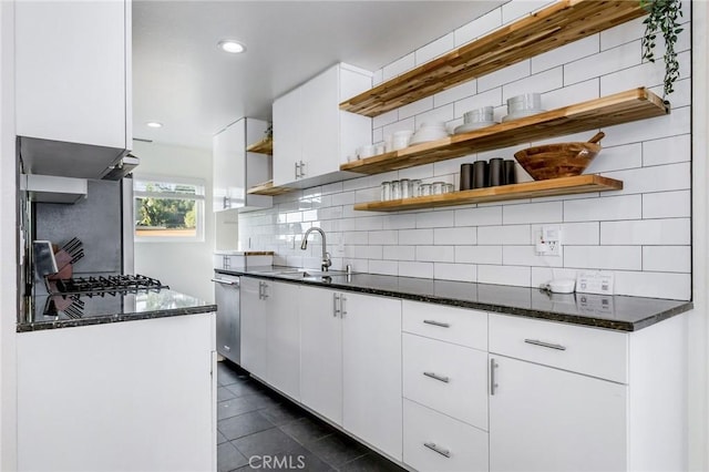 kitchen with open shelves, backsplash, a sink, dark stone counters, and extractor fan